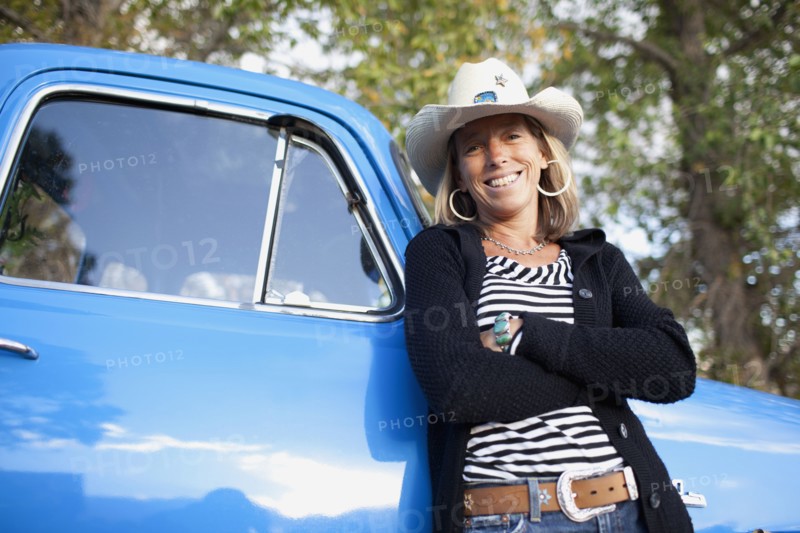 USA, Colorado, Carbondale, Portrait of cowgirl with old fashioned pickup truck. Photo : Noah Clayton