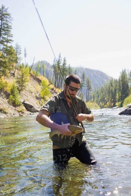 USA, Montana, Man fly fishing in North Fork of Blackfoot River. Photo : Noah Clayton