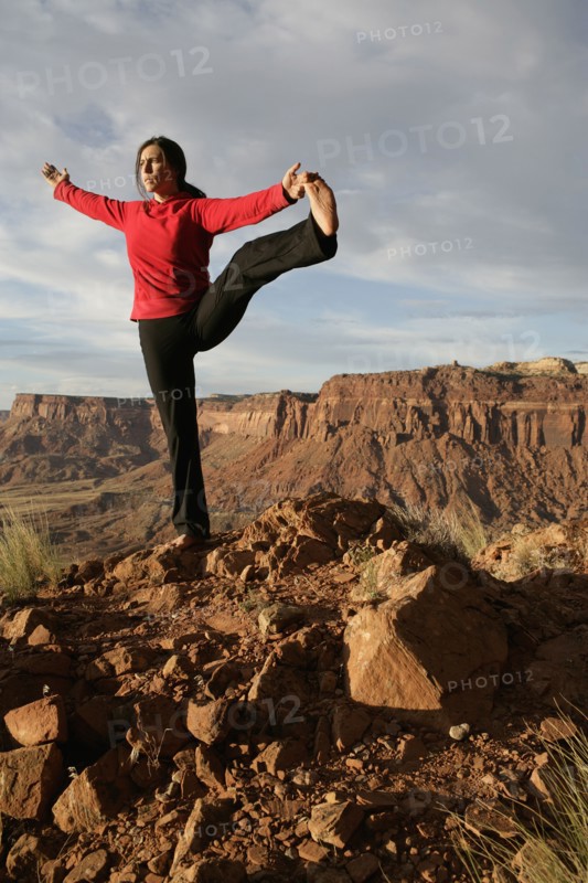 USA, Utah, Canyonlands National Park, woman stretching on rock. Photo : Noah Clayton
