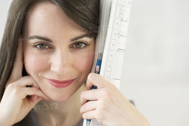 Close-up of woman holding ruler and pencil.