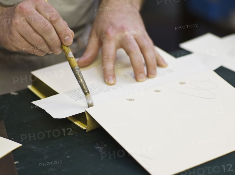 Craftsman making book bindings.