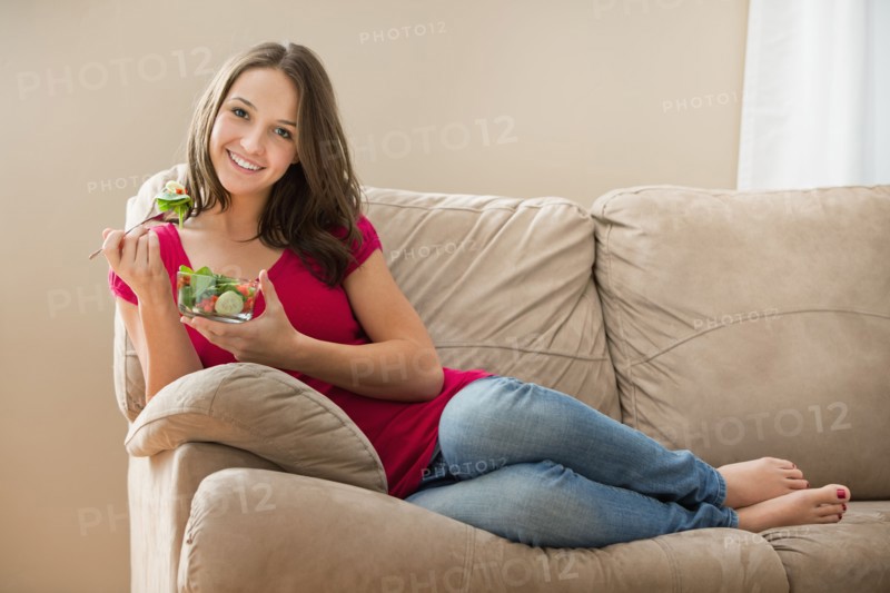 Portrait of young woman eating salad. Photo : Mike Kemp