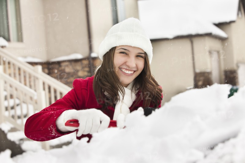 USA, Utah, Lehi, Portrait of young woman scraping snow from car. Photo : Mike Kemp