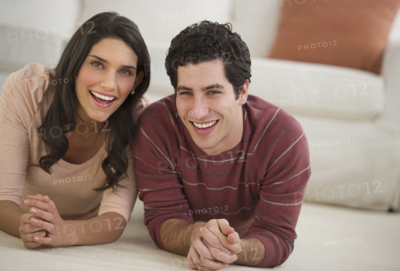 Portrait of couple lying on floor.