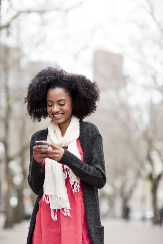 USA, Washington State, Seattle, Cheerful young woman text messaging. Photo : Take A Pix Media