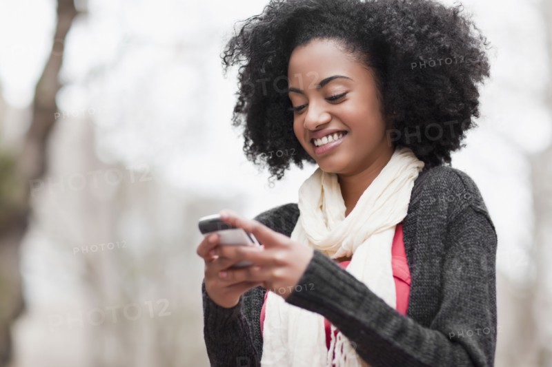 USA, Washington State, Seattle, Cheerful young woman text messaging. Photo : Take A Pix Media