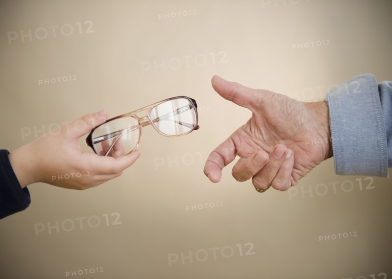 Close up of hands of grandfather and grandson (8-9) with glasses. Photo : Jamie Grill Photography