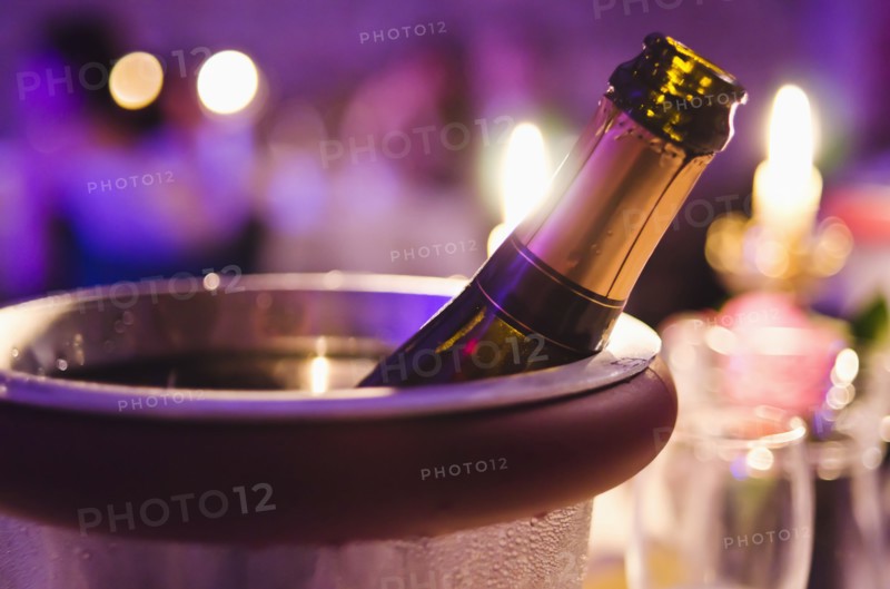 Champagne bottle cooling in ice bucket.