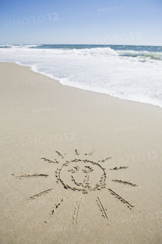 USA, Massachusetts, Sun face drawn on sandy beach. Photo: Chris Hackett