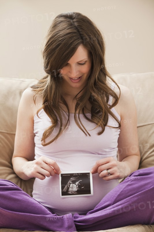 Young pregnant woman looking at CT image of unborn baby. Photo: Mike Kemp
