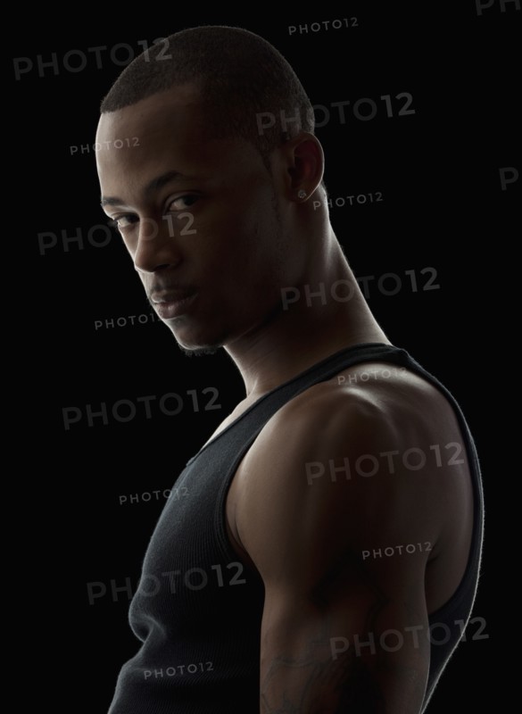 Studio portrait of muscular young man wearing tank top. Photo: Mike Kemp