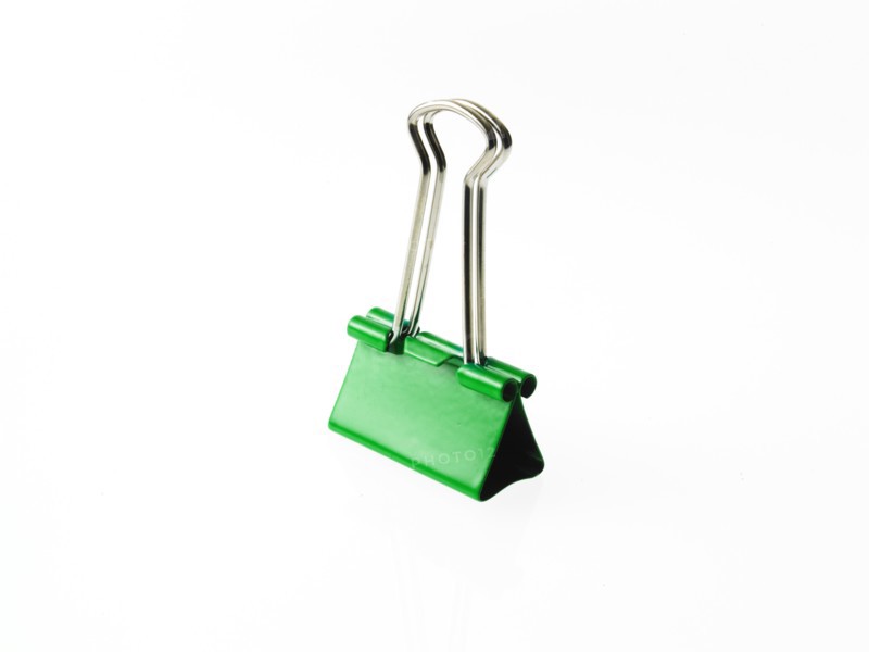 Green bulldog clip on white background. Photo: David Arky