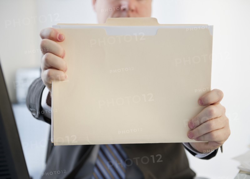 Businessman holding folder. Photo: Jamie Grill Photography