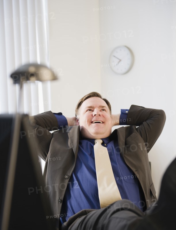 Businessman relaxing in office. Photo : Jamie Grill Photography