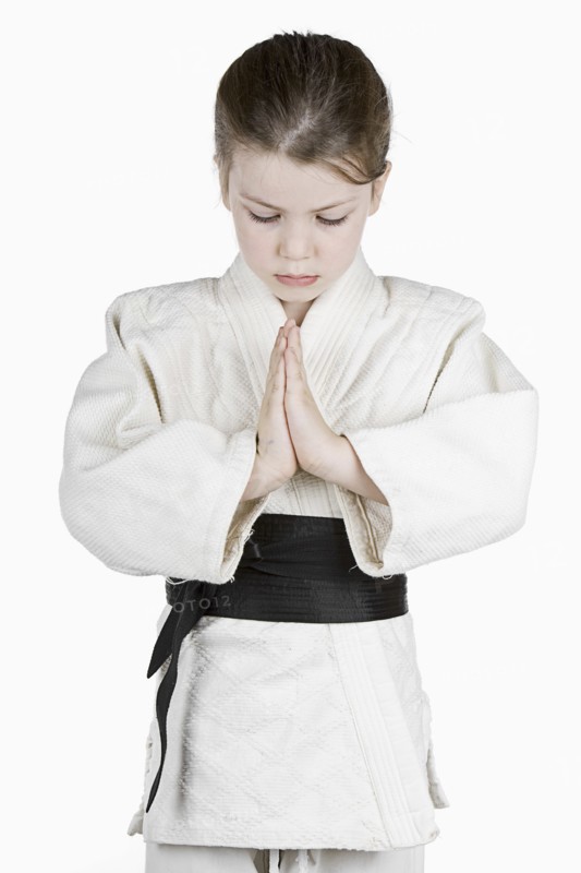 Studio portrait of girl (6-7) wearing karate uniform. Photo : Justin Paget