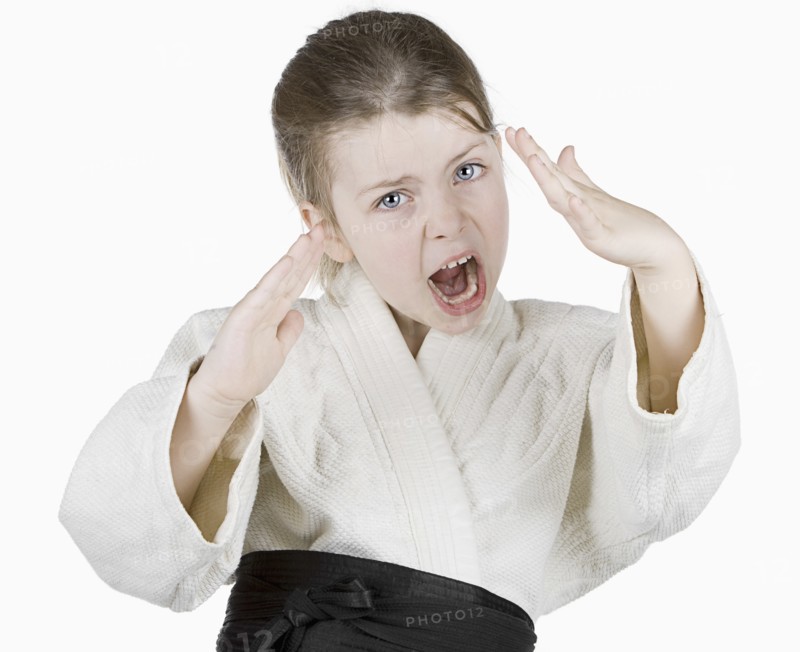 Studio portrait of girl (6-7) wearing karate uniform. Photo : Justin Paget