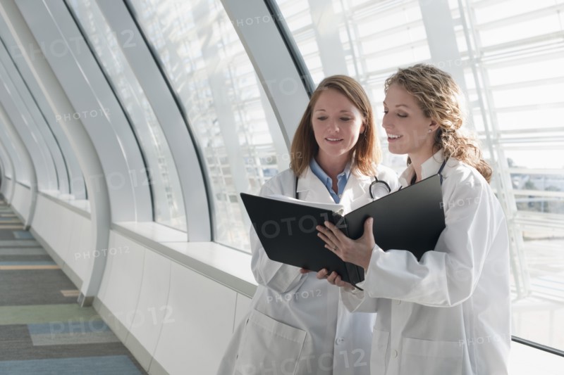Two female doctors reading record. Photo : Mark Edward Atkinson