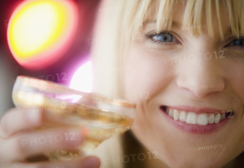 Young woman drinking champagne. Photo : Jamie Grill Photography