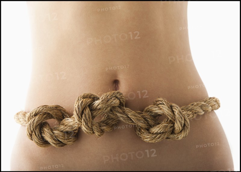 Young woman with knots in stomach. Photo : Mike Kemp