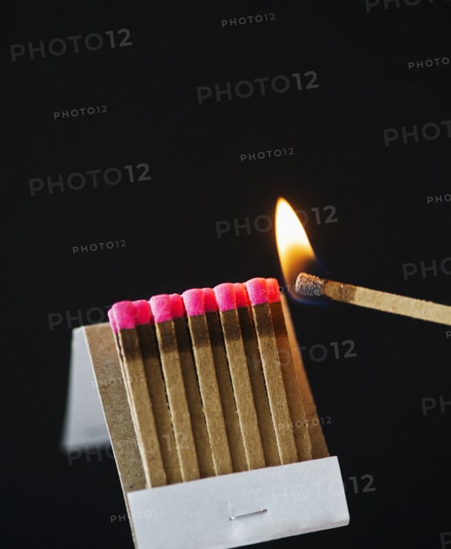 Close up of matches with one burning.