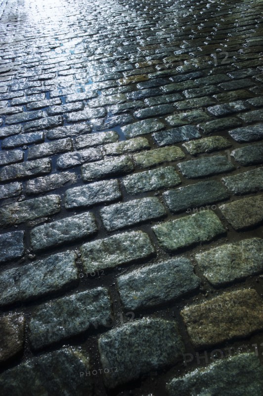 USA, New York, New York City, close up of cobblestone street at night.