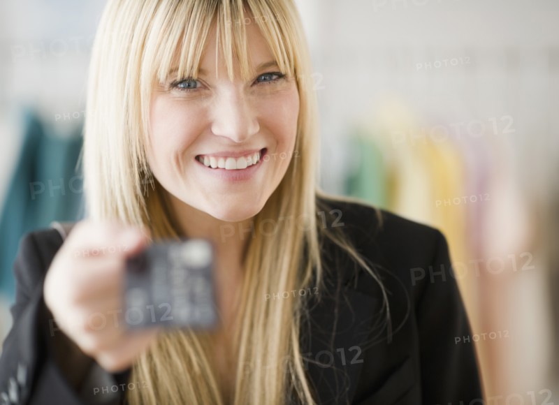 Young woman holding credit card. Photo: Jamie Grill Photography
