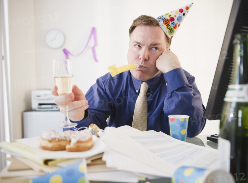Businessman at office party. Photo : Jamie Grill Photography