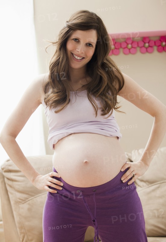 Young pregnant woman showing belly. Photo: Mike Kemp