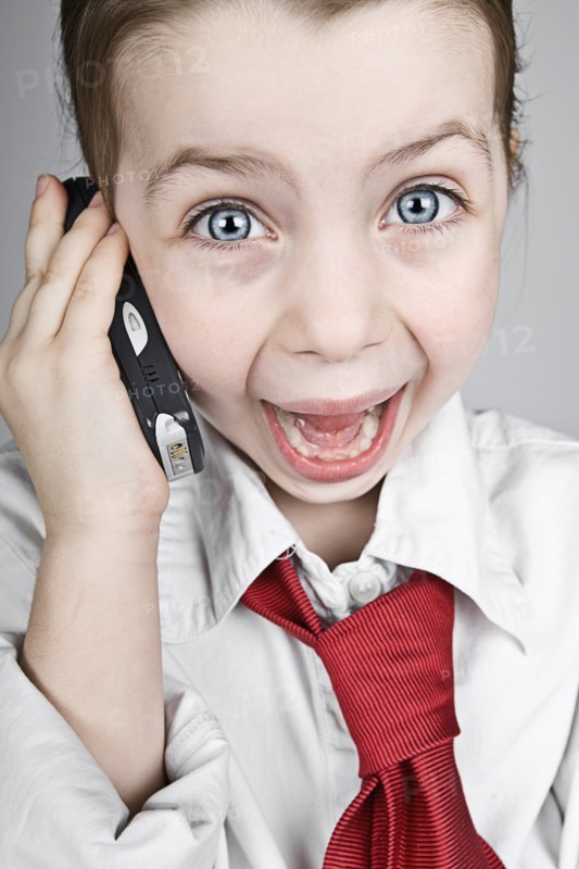 Studio portrait of girl (6-7) dressed-up as businesswoman. Photo : Justin Paget