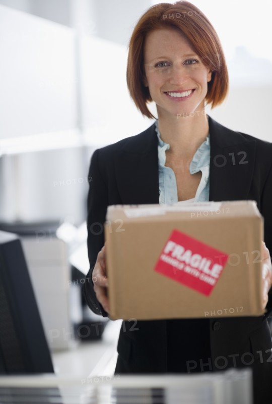 Businesswoman holding box. Photo: Jamie Grill Photography