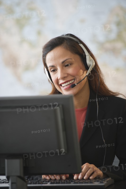 Female customer service representative with headset working on computer.