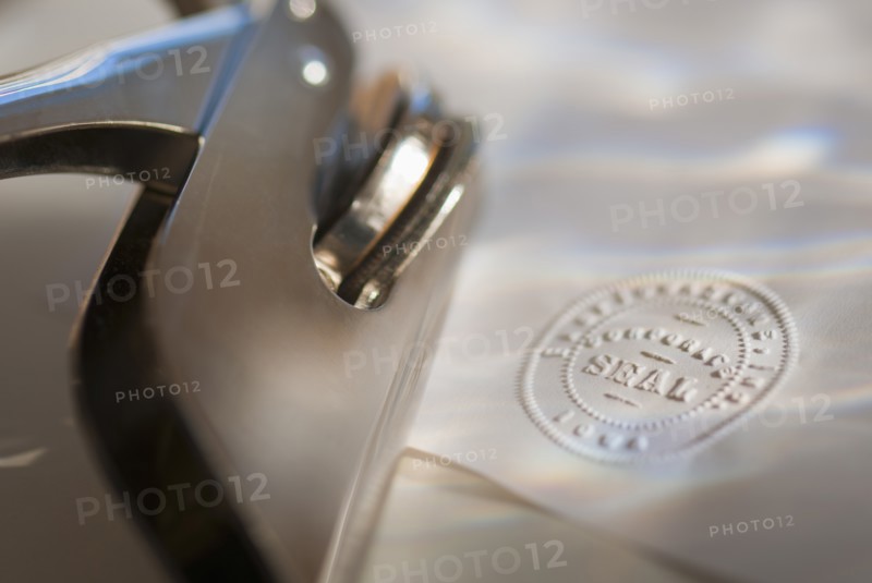 Close up of stamper and corporate seal on paper.