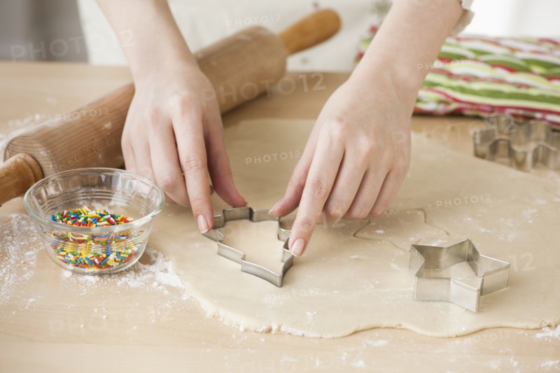Woman preparing biscuits with pastry cutter.