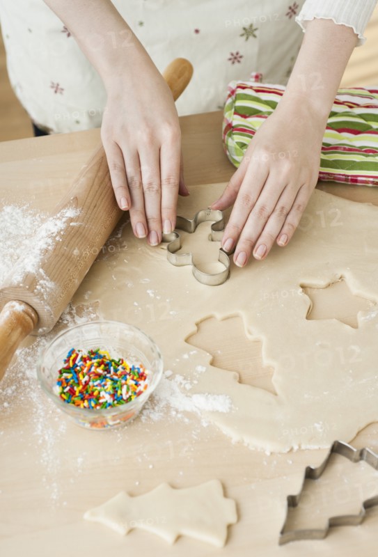 Woman preparing biscuits with pastry cutter.