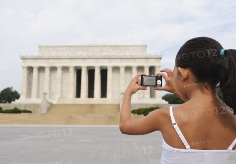 USA, Washington DC, girl (6-7) photographing Lincoln Memorial. Photo : Chris Grill