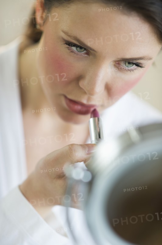 Woman applying lipstick.