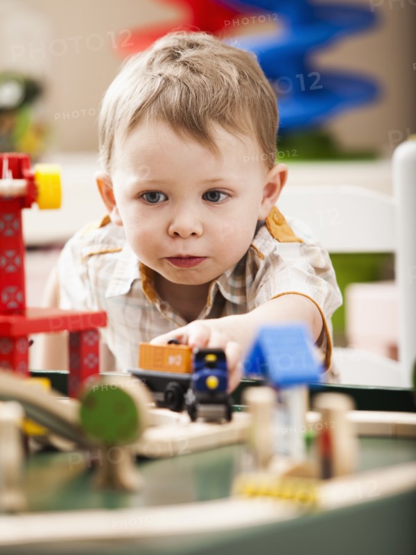 Boy (2-3) playing with toy train. Photo: Mike Kemp