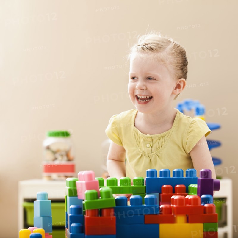 Smiling girl (2-3) playing with colorful blocks. Photo: Mike Kemp