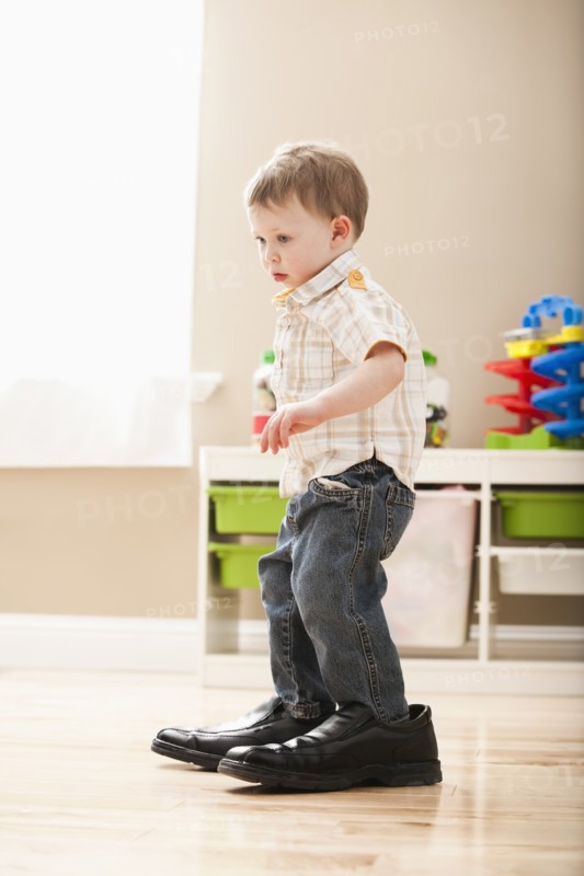 Boy (2-3) walking in dad's shoes. Photo: Mike Kemp