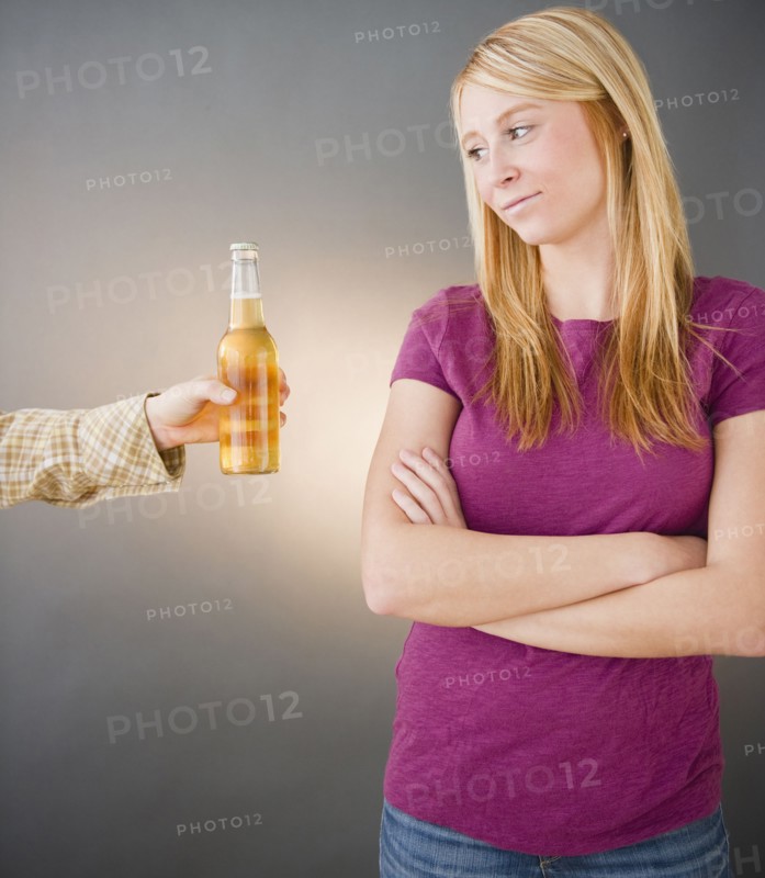 Young woman being offered beer. Photo : Jamie Grill Photography