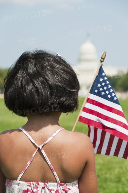USA, Washington DC, girl (10-11) with US flag in front of Capitol Building. Photo: Chris Grill