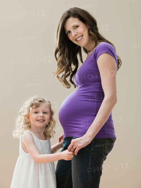 Portrait of girl (2-3) and pregnant mother. Photo: Mike Kemp