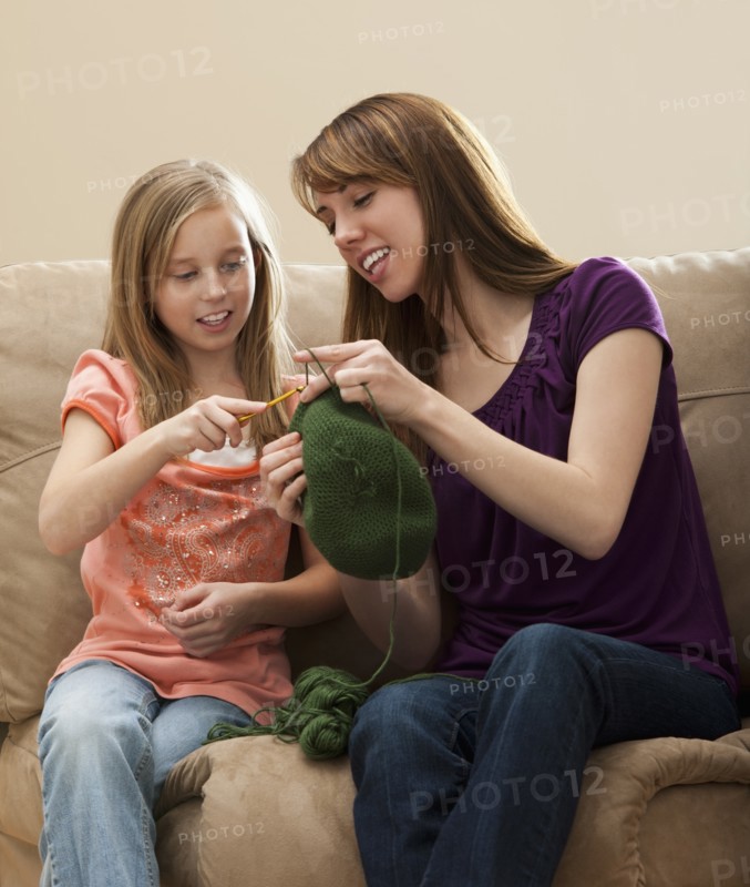 Mother giving daughter (8-9) knitting tips. Photo : Mike Kemp