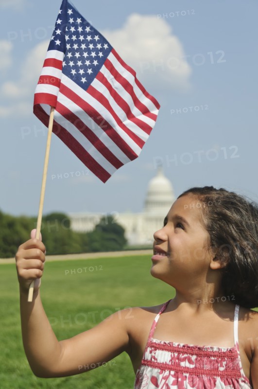 USA, Washington DC, girl (10-11) with US flag in front of Capitol Building. Photo : Chris Grill