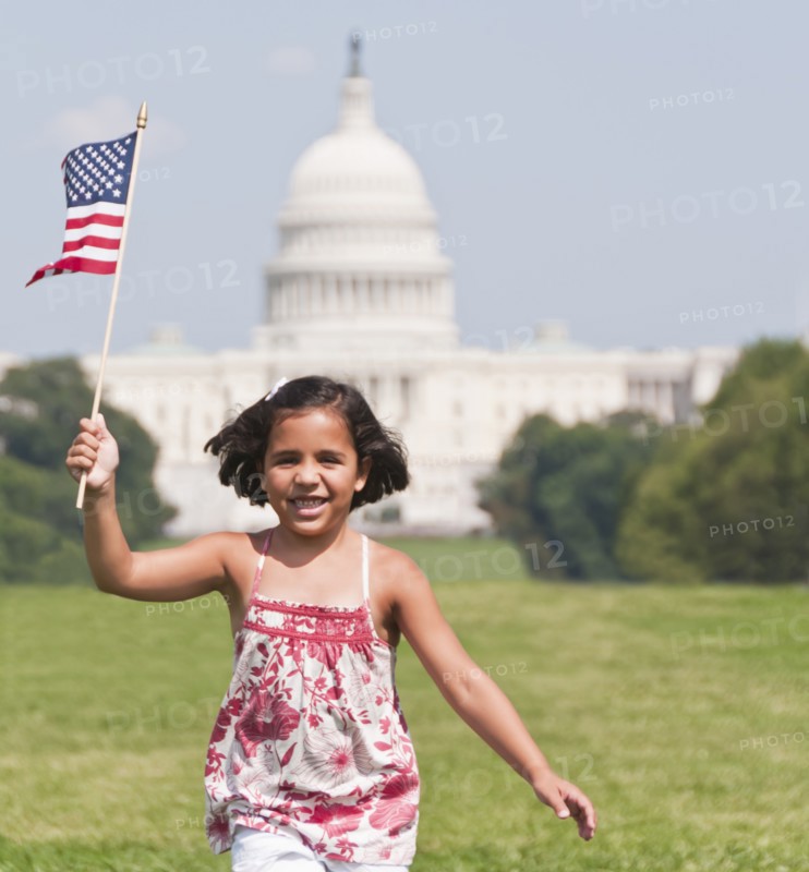 USA, Washington DC, girl (10-11) with US flag running in front of Capitol Building. Photo: Chris Grill