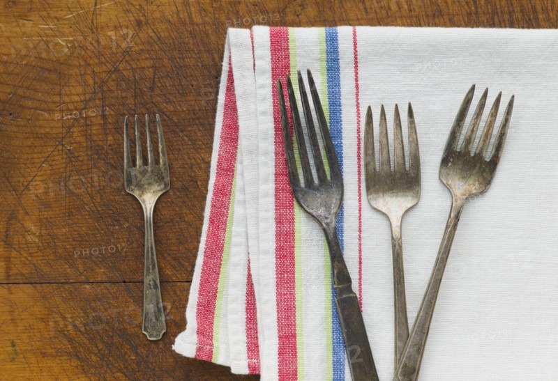 Close up of rusty silver forks and napkin.