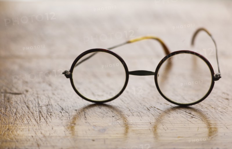 Close up antique round glasses on wooden table.