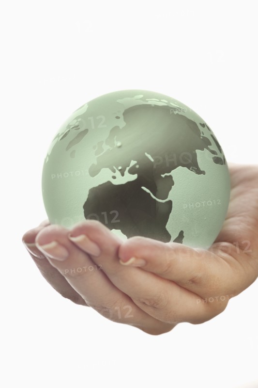 Studio shot of woman holding glass globe model.