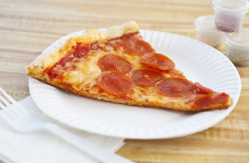 Slice of pepperoni pizza on plate.