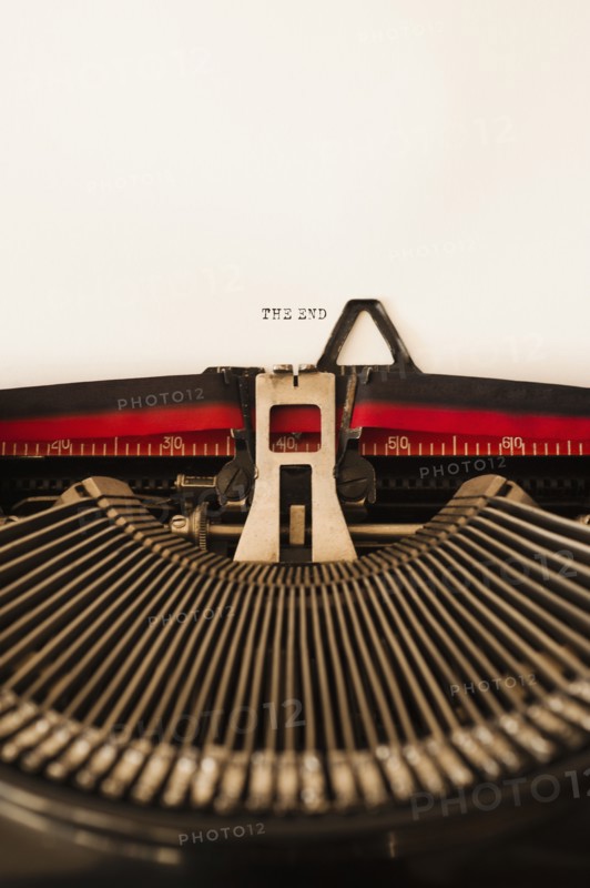 Close up of antique typewriter with "the end" print on page.